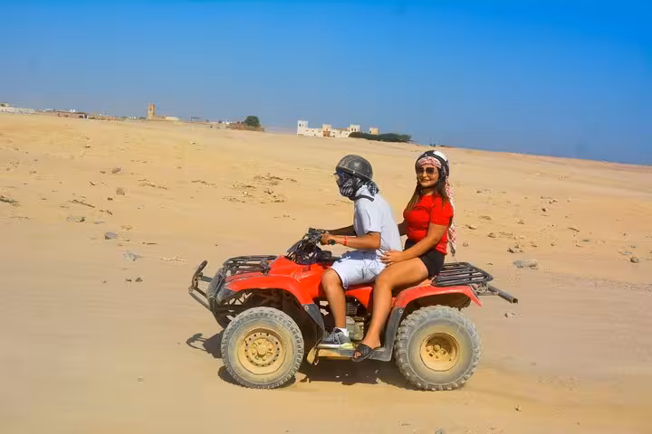 Two riders on red quad bike in Hurghada desert safari, 3-hour tour with camel ride and free shopping
