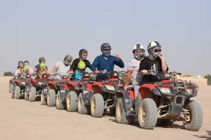 Group of riders lined up on quad bikes in Hurghada desert, 3-hour safari adventure with helmets and scarves