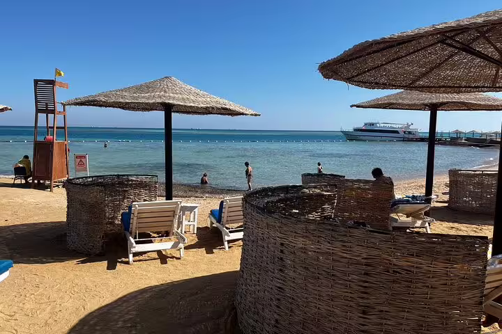 Hurghada Red Sea beach with sun loungers and umbrellas, relaxing stop on 10-day Egypt tour with flights
