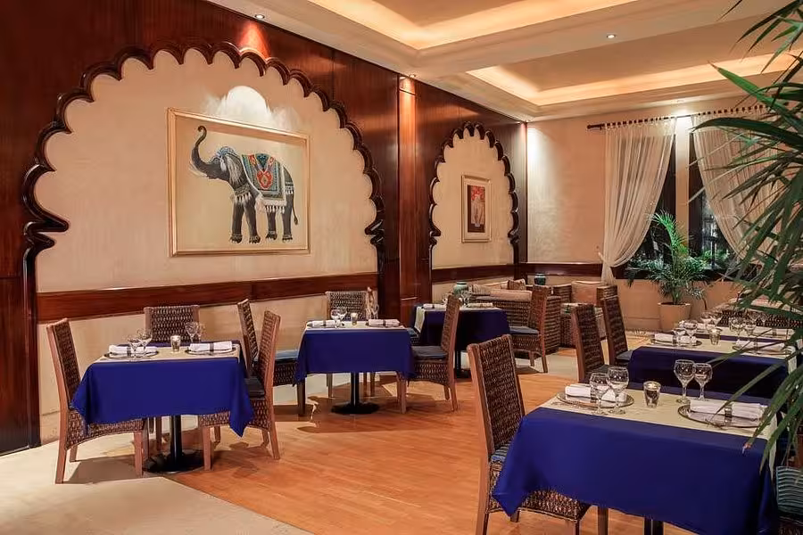 Elegant Hurghada restaurant with blue tablecloths and elephant art, ideal for dining during your Egypt vacation.