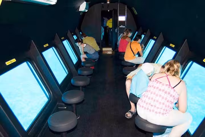 Passengers viewing Red Sea marine life through large windows on Hurghada semi-submarine underwater tour