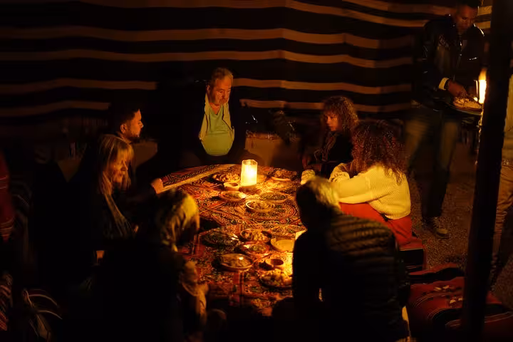 Guests dining in a Bedouin tent during Hurghada stargazing jeep safari, with optional ATV add-on