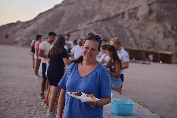 Tour guests enjoy desert dinner buffet on Hurghada stargazing jeep safari with optional ATV quad bike ride