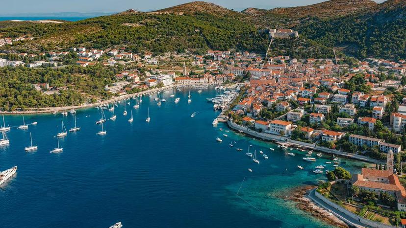Aerial of Hvar town harbor with yachts and turquoise coves, scenic route on Hvar Brac Pakleni boat tour