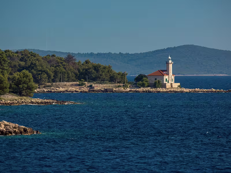 Coastal lighthouse on a rocky islet in the Adriatic Sea, picturesque cruising route on a private Hvar Brac Solta tour