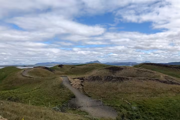 Expansive view of Hverfjall crater and lush landscapes on a clear day during Lake Myvatn tour.