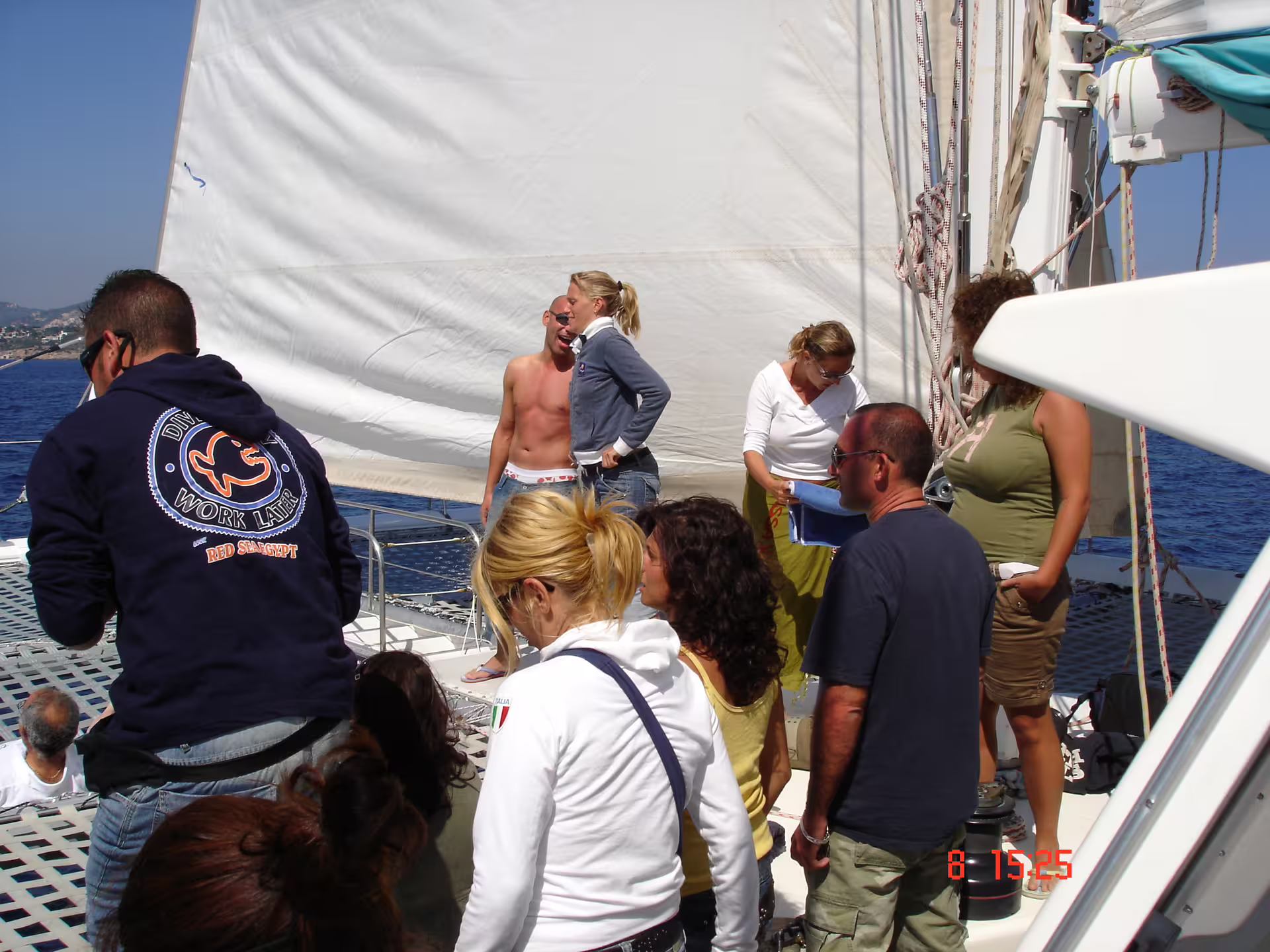 Group enjoying Ibiza catamaran sailing toward Illetas, Formentera, with crew, snacks and lunch on deck