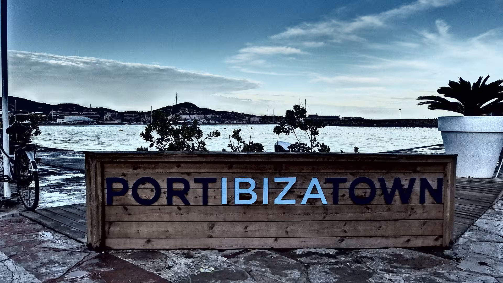 Port Ibiza Town waterfront sign at dusk, meeting point view for Dalt Vila night tour with official guide