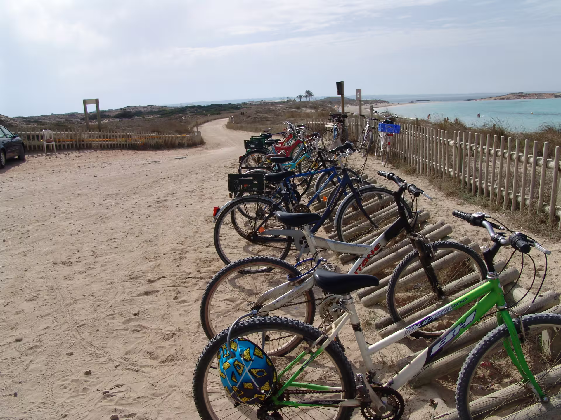 Bikes parked by sandy beach path in Formentera on Ibiza day trip with ferry transfer and cycling tour