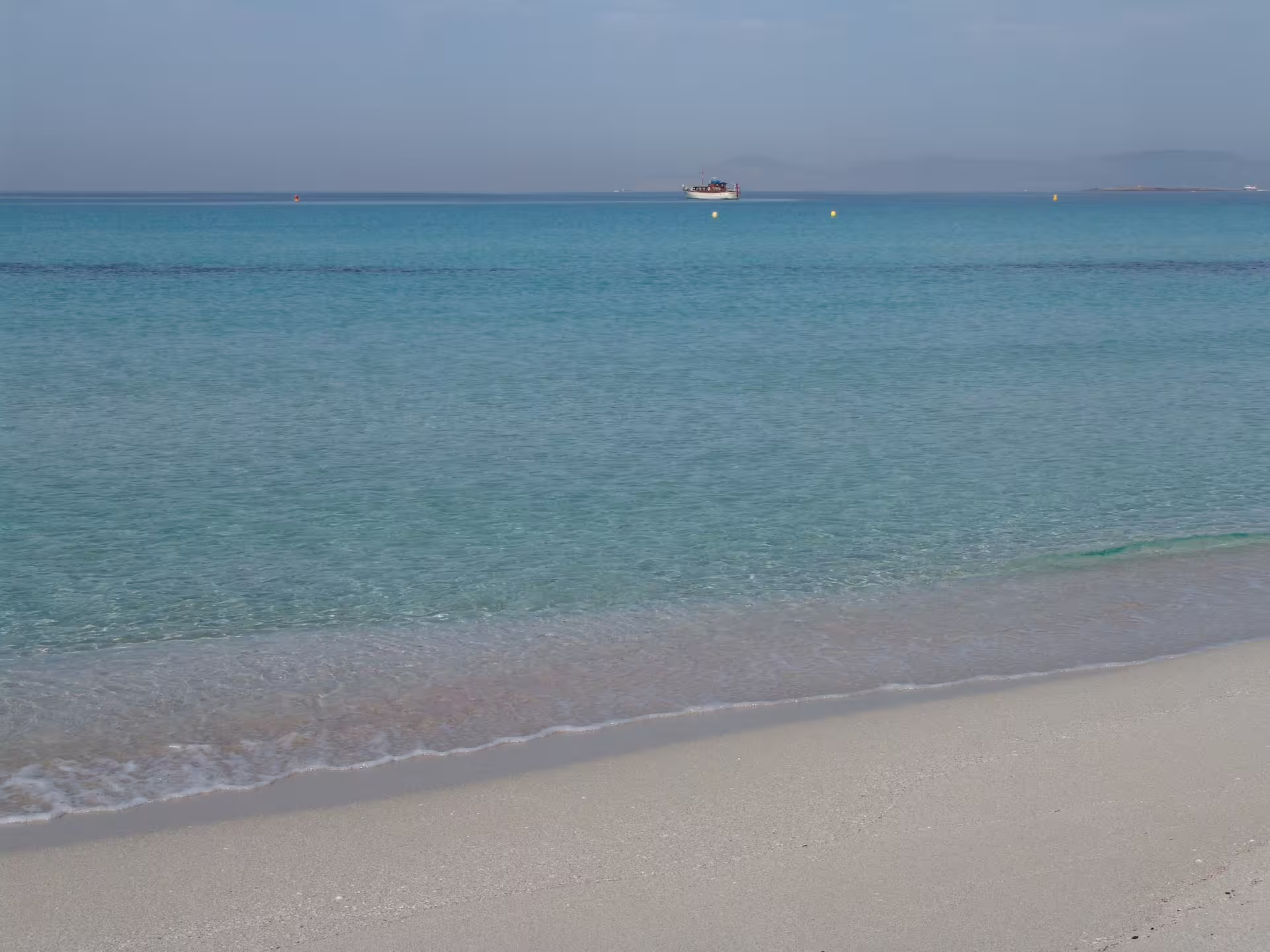 Crystal-clear Ibiza shoreline and calm sea, scenic view on Ibiza bus tour with fast ferry and official guide