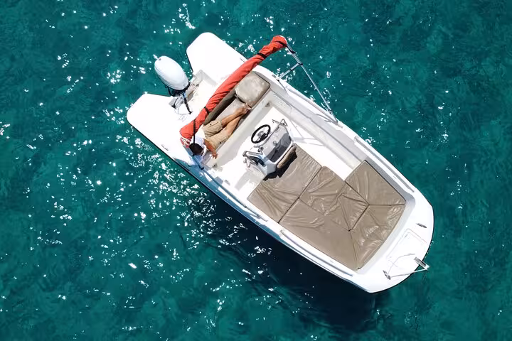 Aerial view of a sleek motorboat cruising the clear waters of Ibiza, perfect for a license-free adventure.