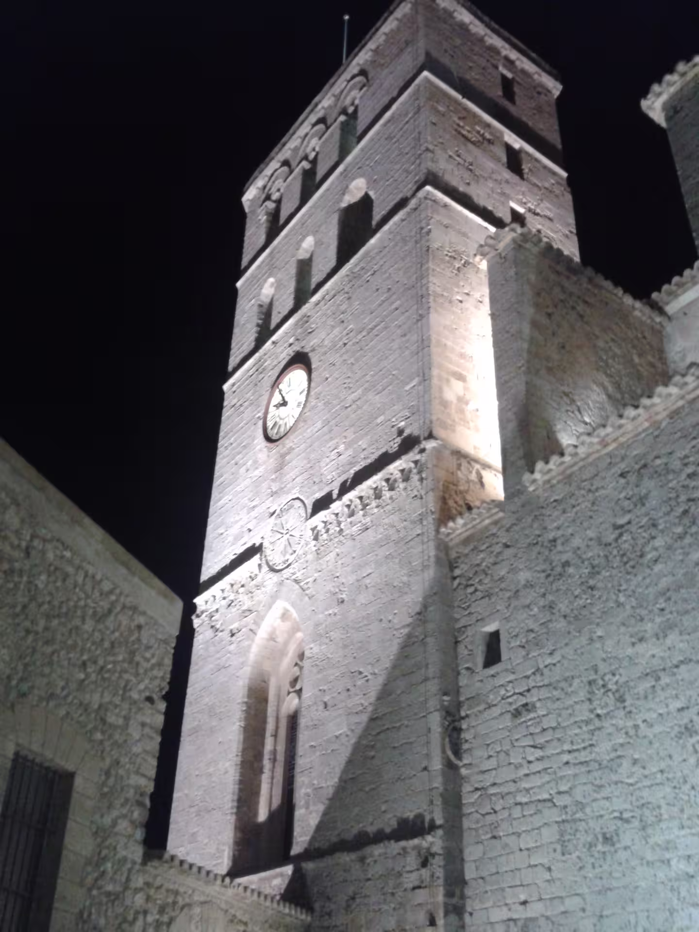 Dalt Vila clock tower lit after dark, highlight of Ibiza Night roundtrip transfer with guide and free time