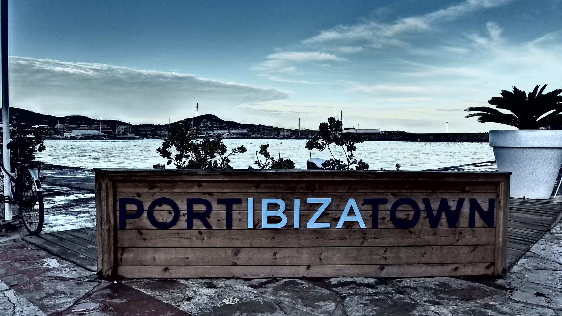 Port Ibiza Town waterfront sign by the marina, meeting point for Ibiza Night hotel-to-port roundtrip transfer