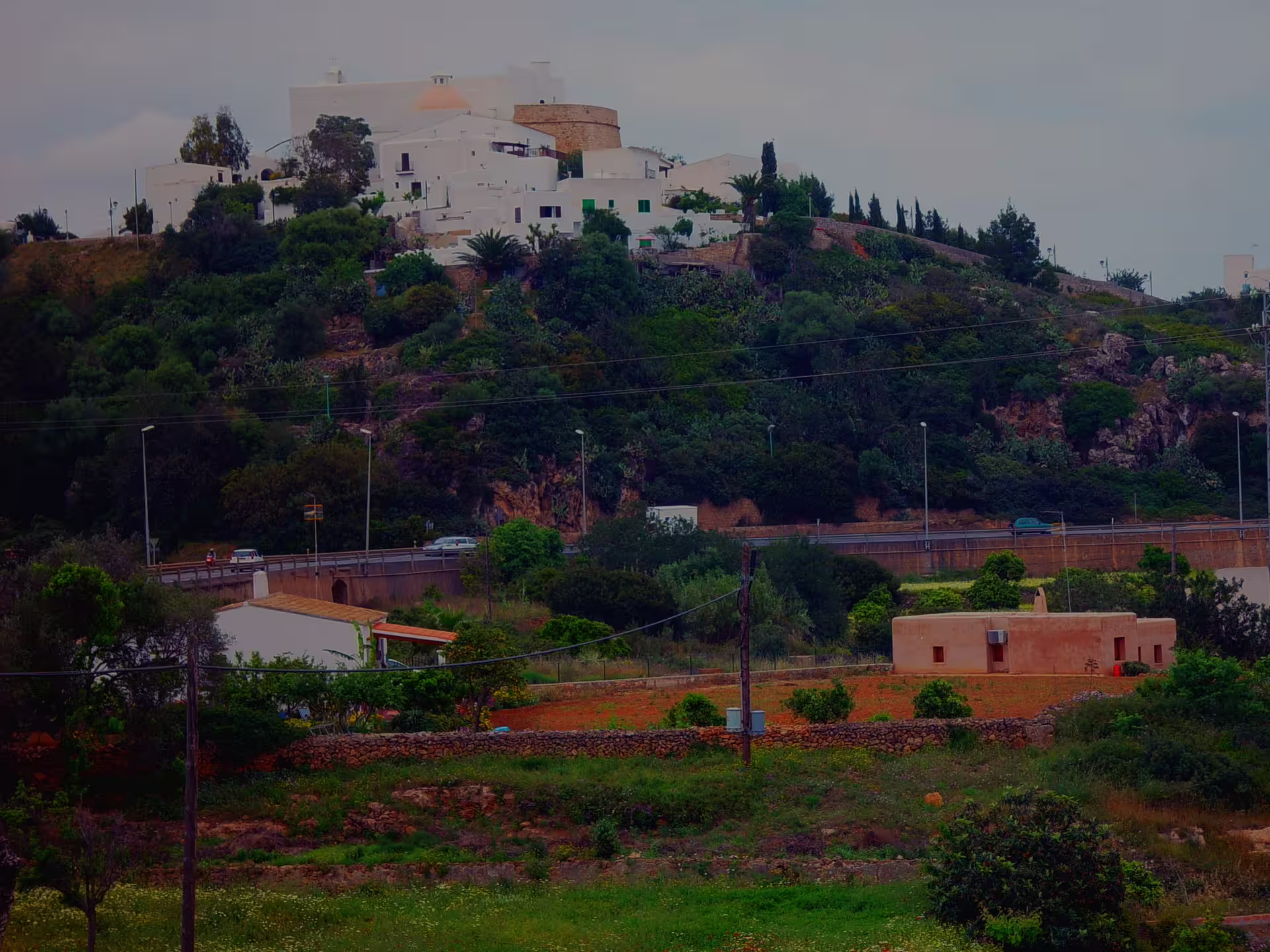 White hilltop village and historic church in rural Ibiza on bus island tour with official guide, panoramic view