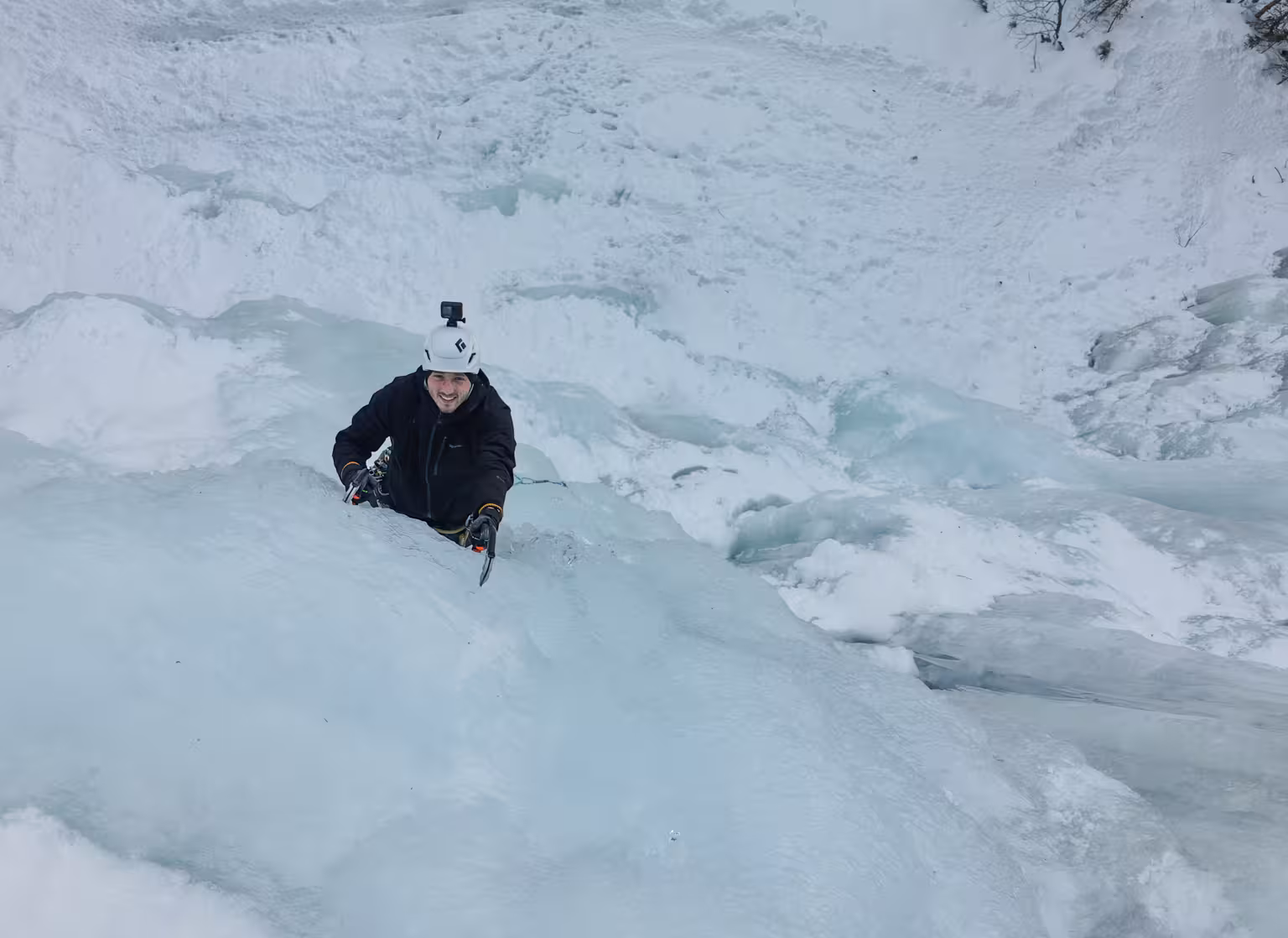 Adventurous ice climber scaling a frozen waterfall in Rovaniemi, Finland, showcasing thrilling winter activities.