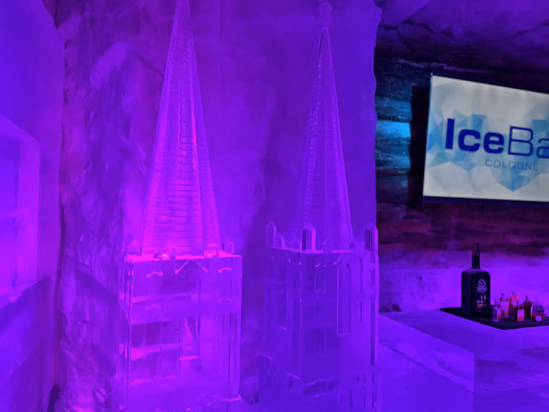 Intricate ice sculptures and vibrant lighting create a magical atmosphere at IceBar Cologne, perfect for a unique experience.