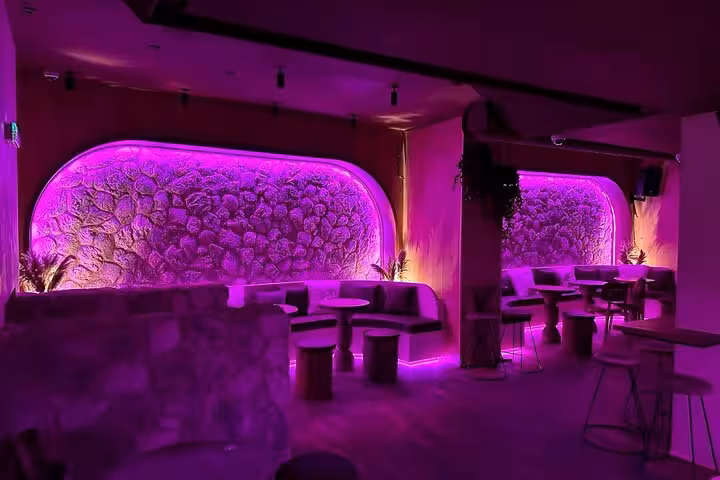 Vibrant IceBar Cologne interior with neon purple lighting and cozy seating perfect for a unique nightlife experience.