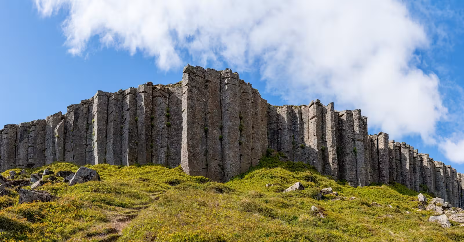 Majestic basalt columns under a clear blue sky in Iceland, highlighting nature's geological wonders.
