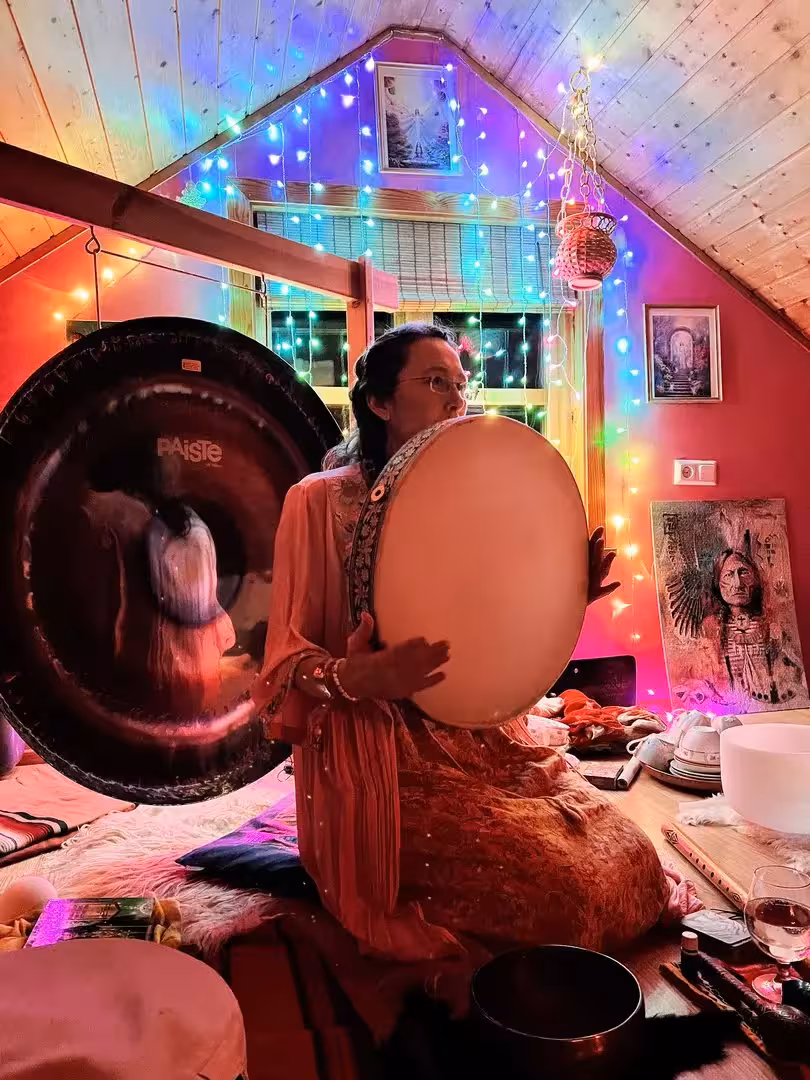 Sound healing drum and gong during Iceland cacao ceremony, cozy Christmas lights, Sacred Iceland tour