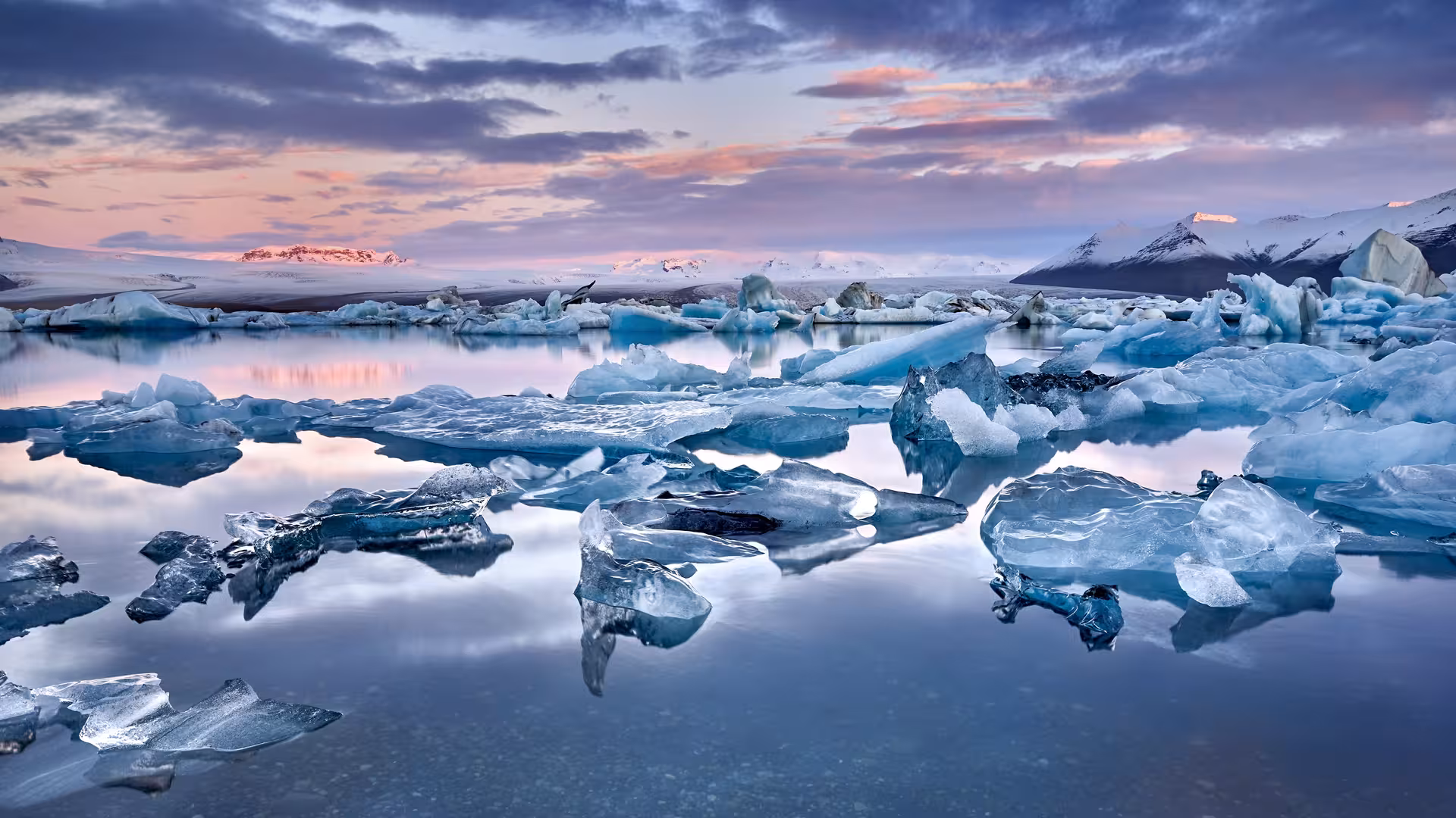 Stunning Jokulsarlon Glacier Lagoon with floating icebergs at sunset, a highlight of Iceland's 8-day self-drive tour.