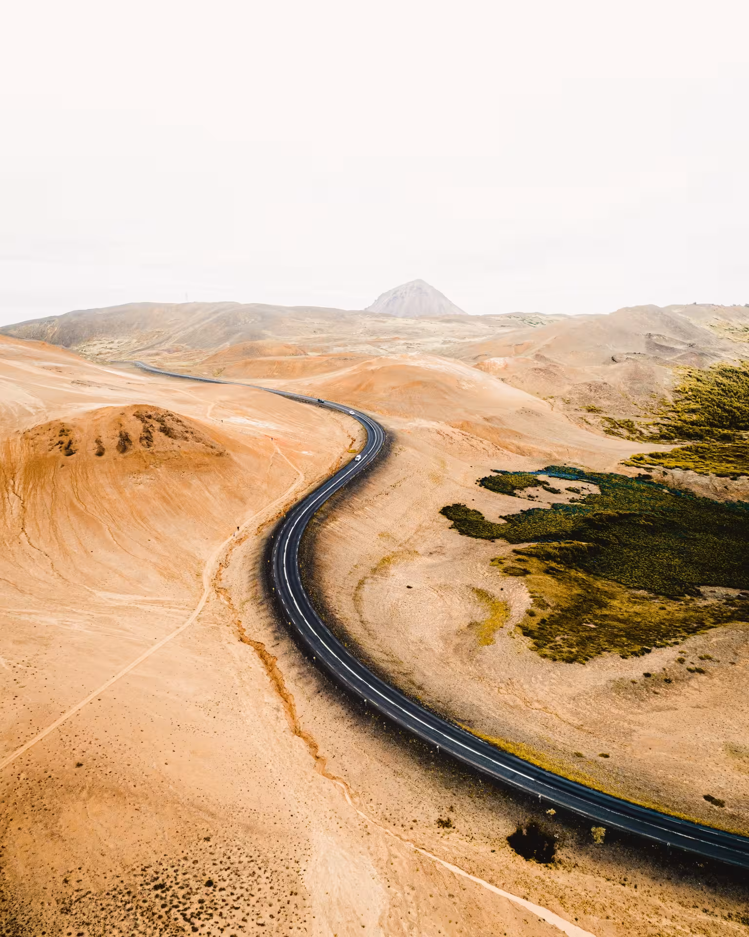 Scenic aerial view of winding road through Iceland's desert landscape, ideal for self-drive exploration tours.