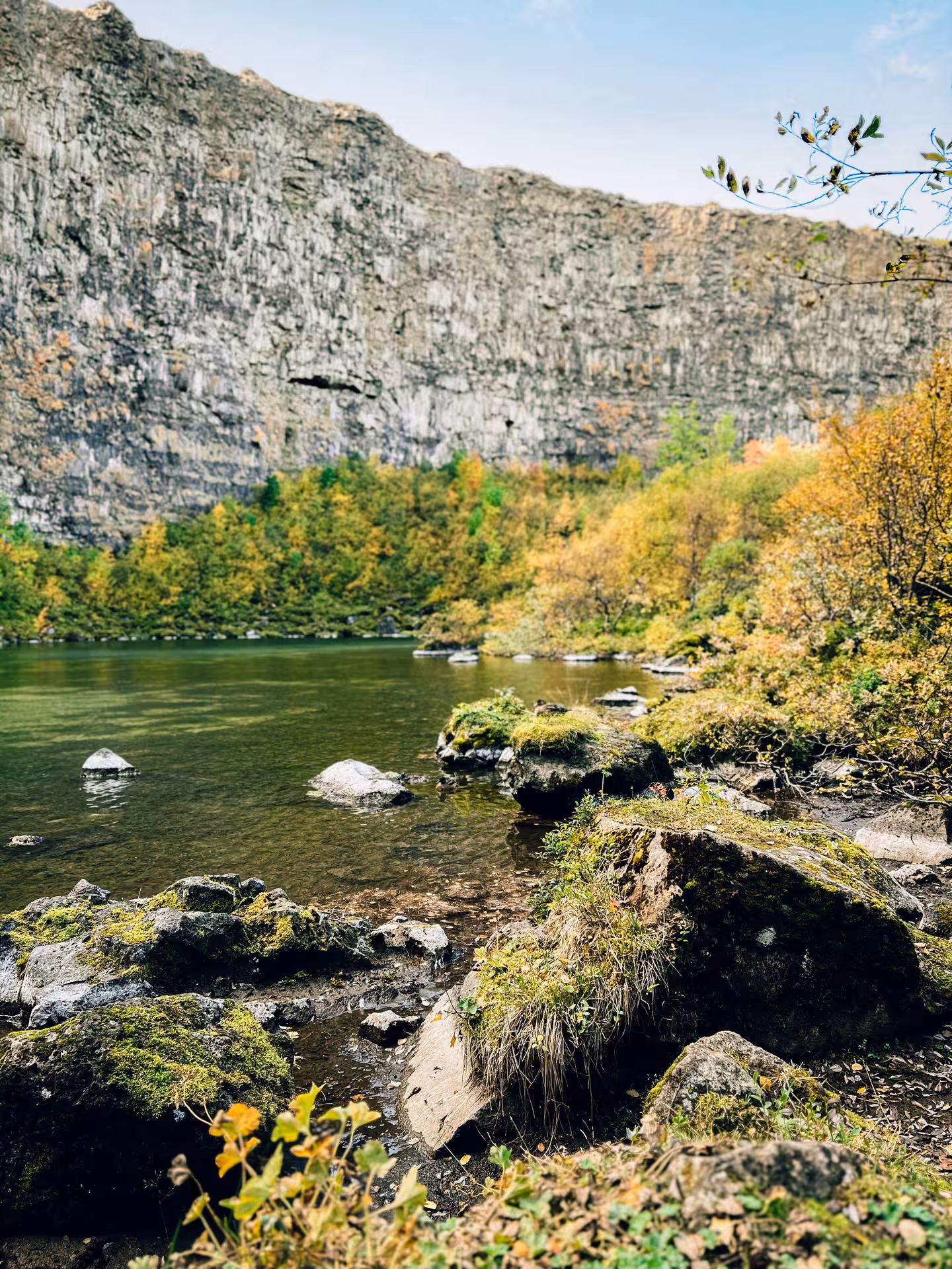 Serene lake and mossy rocks below rugged cliffs on Iceland Private Adventure Diamond Circle Tour