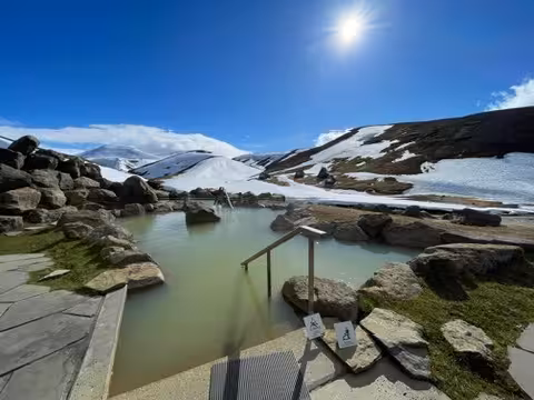 Serene geothermal hot spring surrounded by snow in the Icelandic Highlands, ideal for a winter wellness retreat.