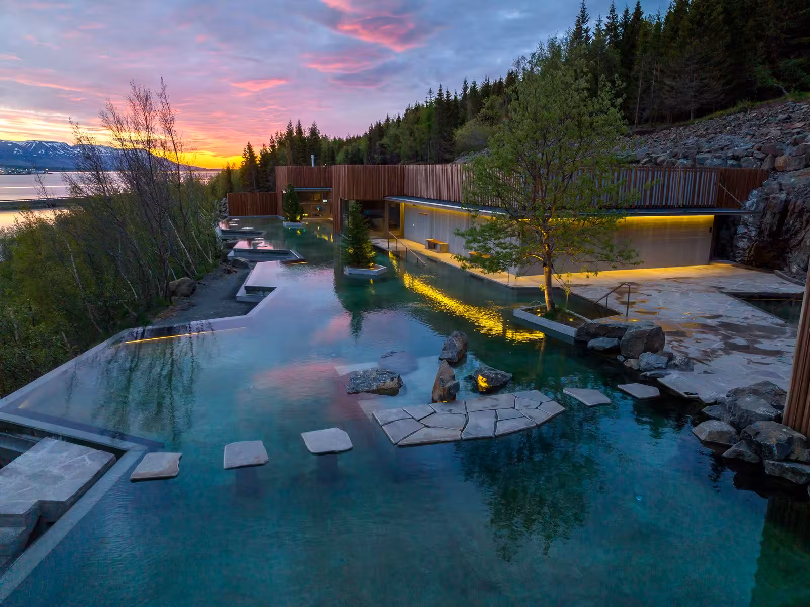 Stunning Icelandic spa at sunset with tranquil waters and vibrant sky reflecting in the geothermal pool.