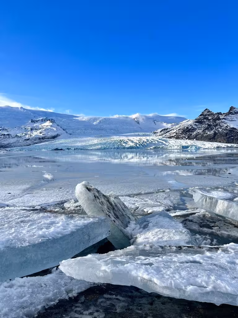 Majestic Icelandic glacier landscape with floating icebergs under a clear blue sky, perfect for New Year's adventure.