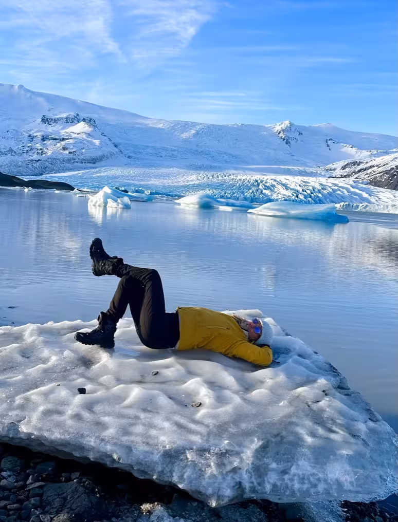 Traveler relaxing on an ice floe at Jökulsárlón Glacier Lagoon in Iceland's stunning landscape.