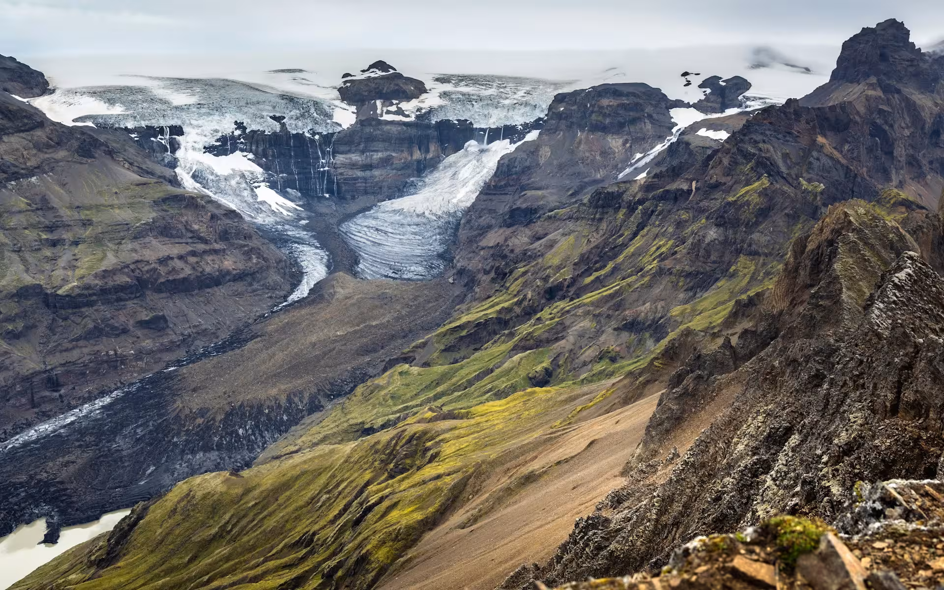 Majestic glacier nestled between rugged mountains, showcasing stunning landscapes on a self-drive Iceland tour.