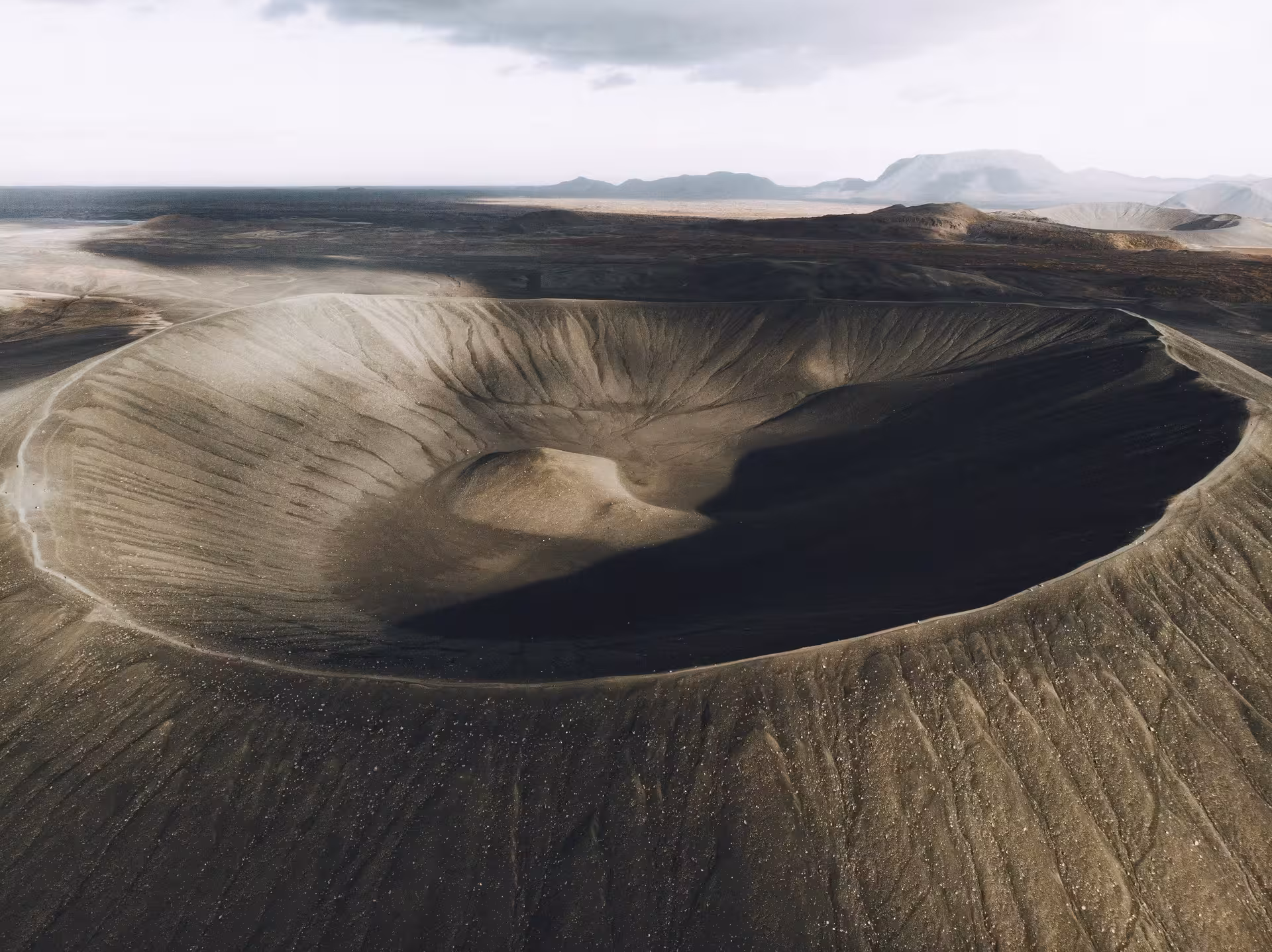 Aerial view of Iceland's Hverfjall volcanic crater, showcasing dramatic geological formations on the grand tour.