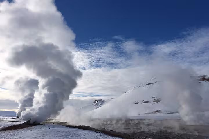 Steam rising from geothermal vents in a snowy landscape near Lake Myvatn, showcasing Iceland's geothermal wonders.