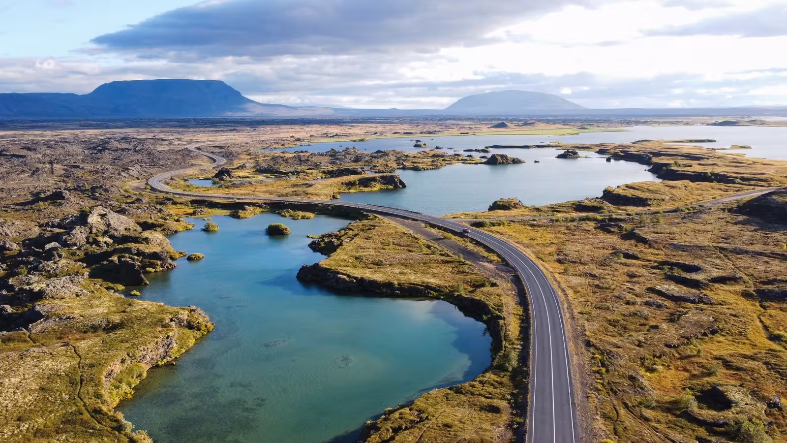 Scenic aerial view of Lake Mývatn with winding roads and volcanic landscapes, perfect for a 9-day Iceland self-drive adventure.