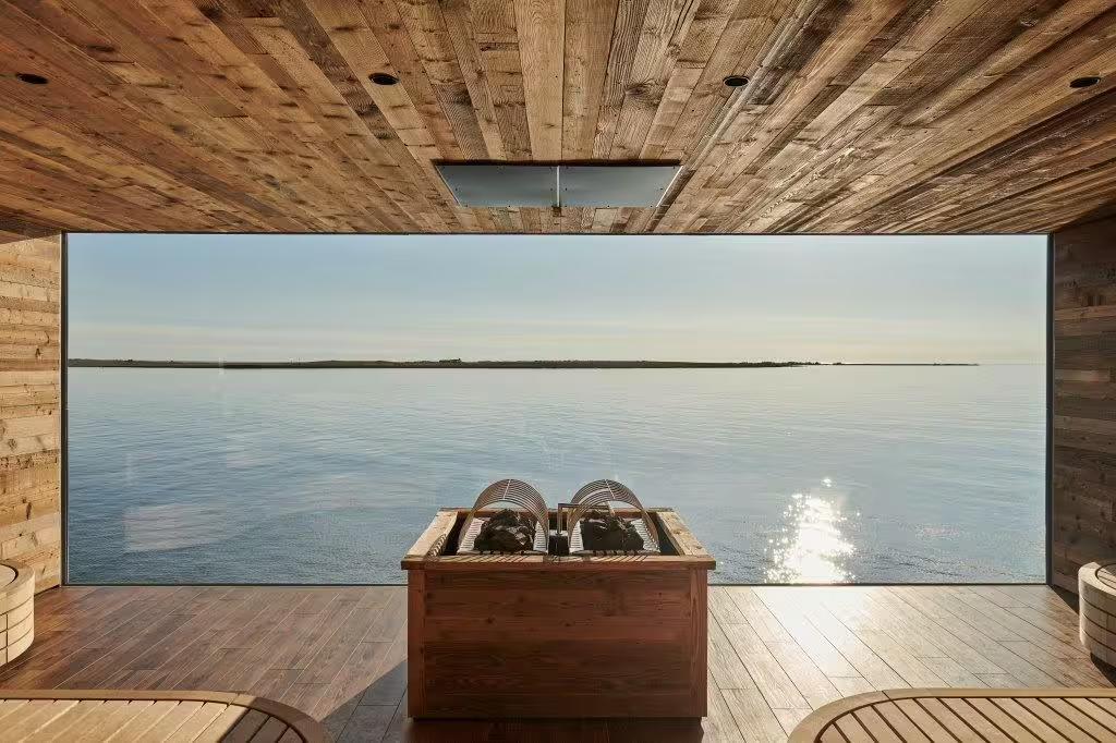 Serene view from a Sky Lagoon sauna overlooking a calm ocean, showcasing the tranquil experience of Iceland's Cold & Hot tour.
