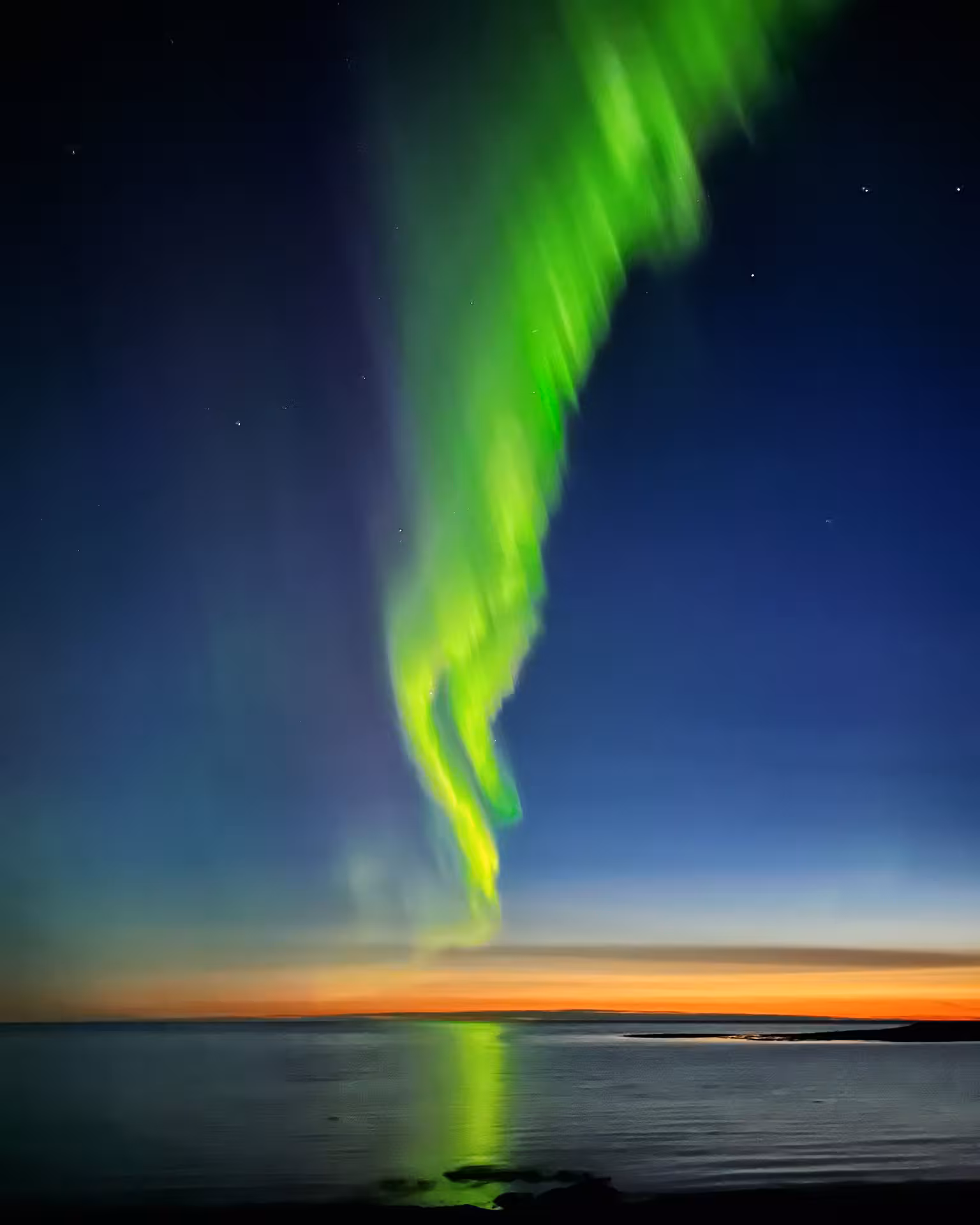 Vibrant Northern Lights over Icelandic coast, perfect for a winter knitting tour under the aurora borealis.