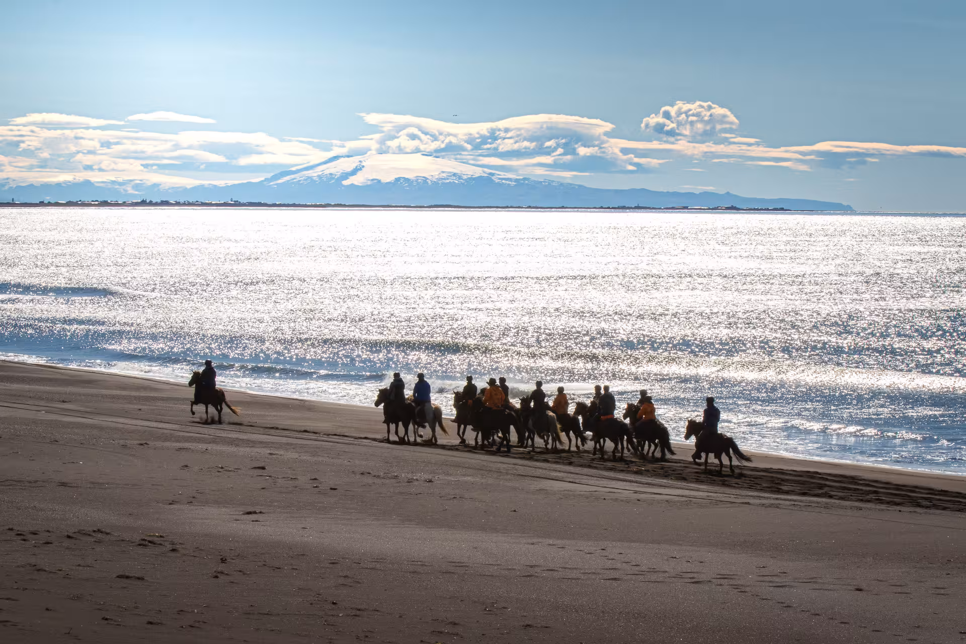 Group on Icelandic horses riding a black sand beach on 06A The Beach Ride with ocean and glacier views