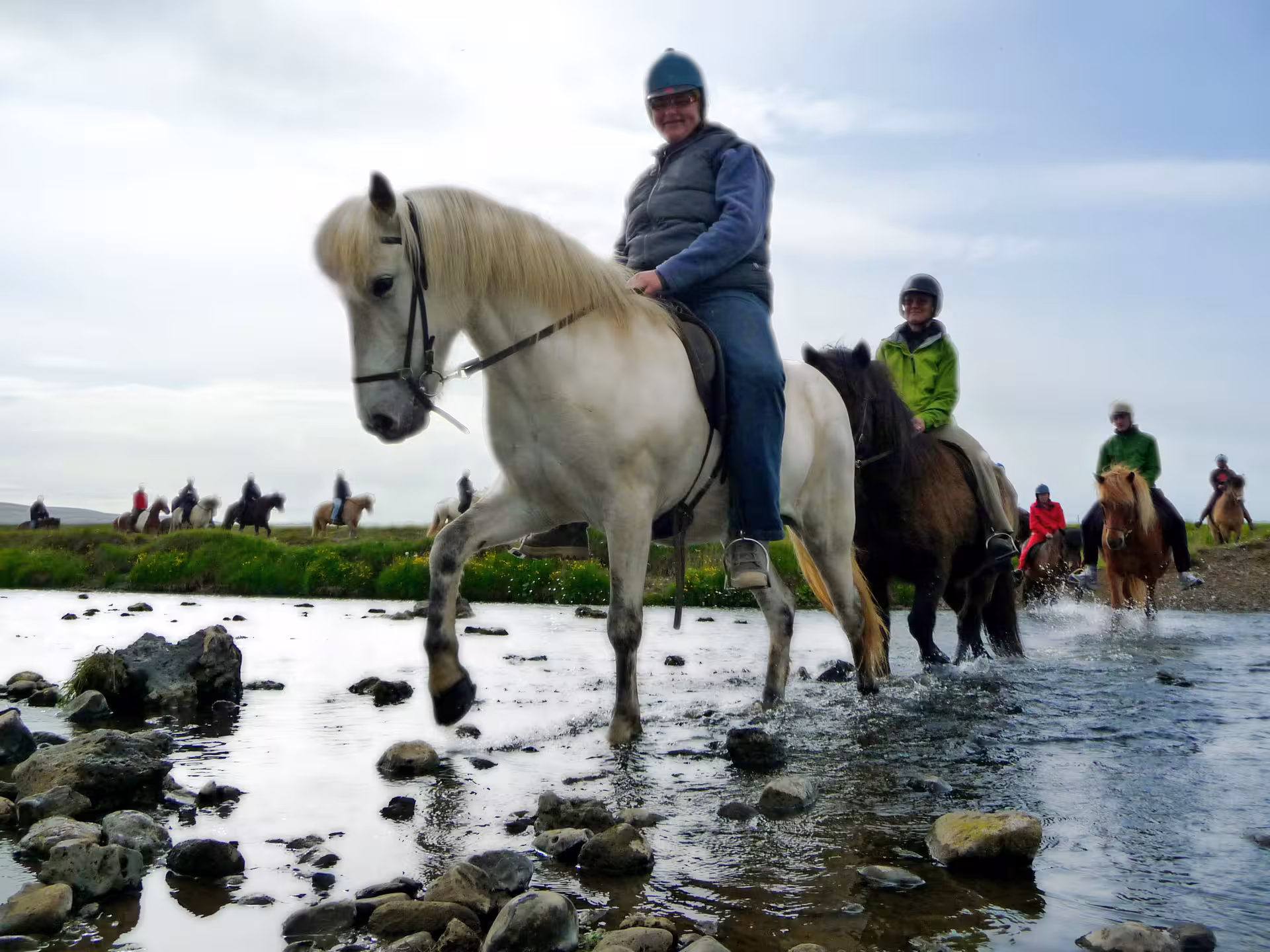 Riders on Icelandic horses crossing a shallow river on 02E The Elfin Tour, scenic countryside trek