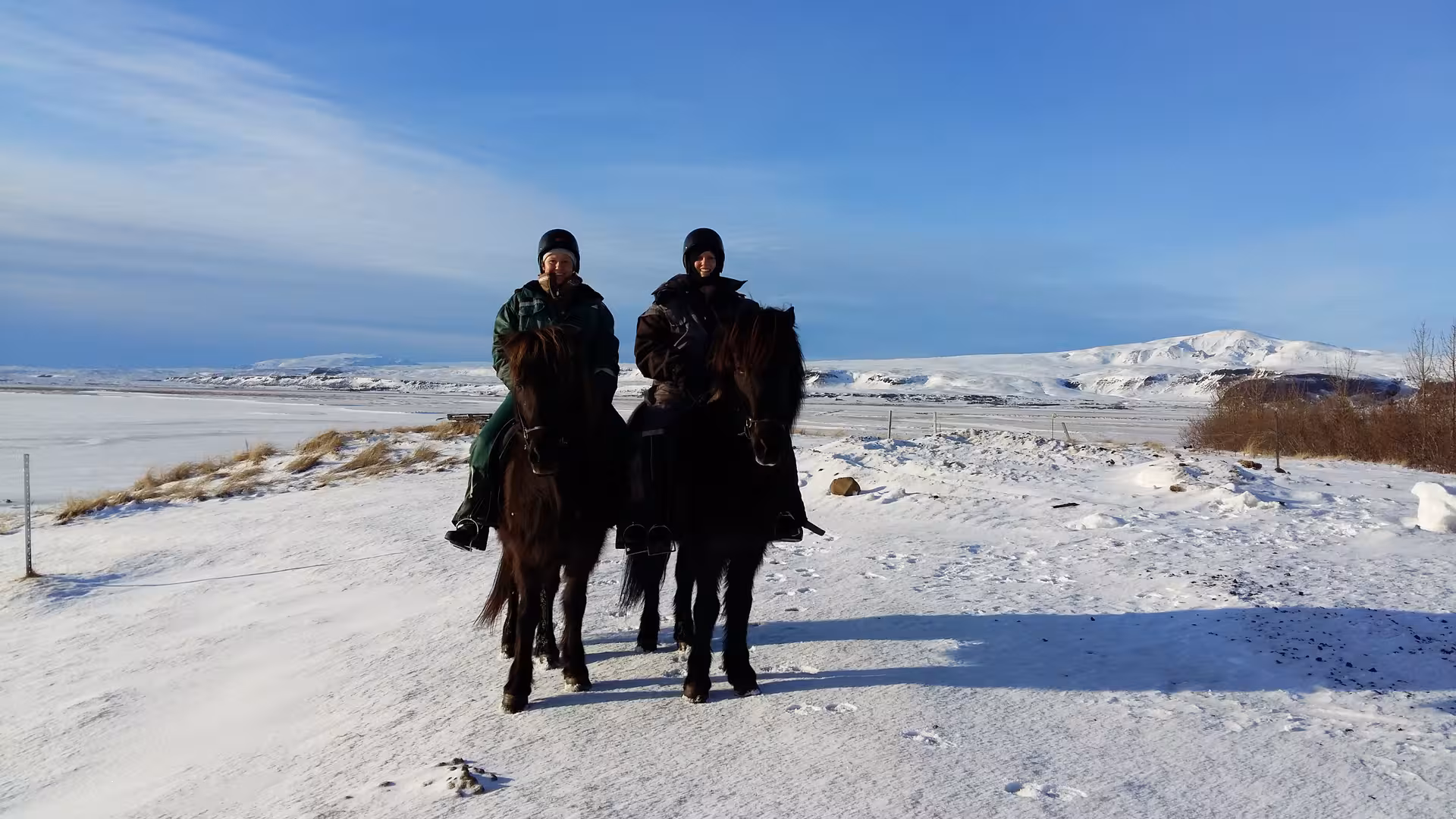 Two riders on Icelandic horses in a winter landscape with snowy mountains on 05B Below the Mountains