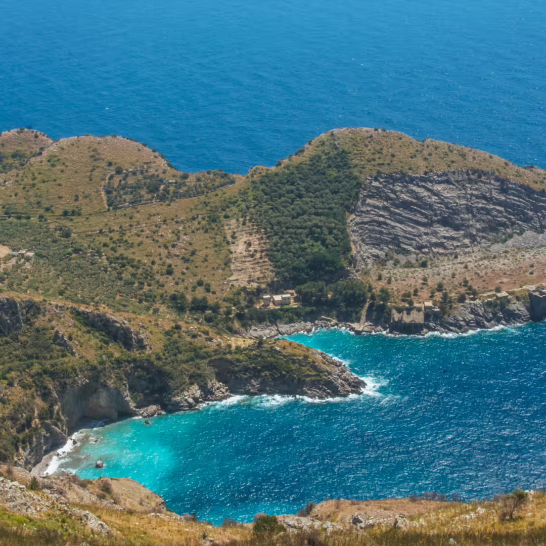 Aerial view of Ieranto Bay with turquoise water, rugged coastline and hiking trails on Punta Campanella trekking weekend