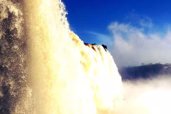 Majestic Iguazu Falls cascading under a clear blue sky, showcasing the grandeur of this natural wonder.