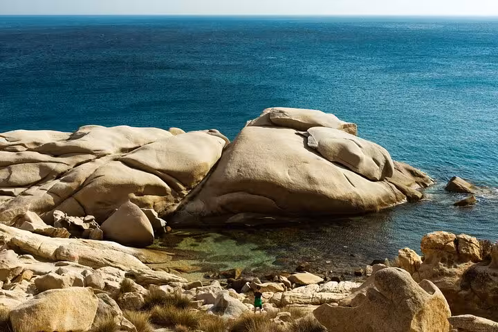 Smooth granite rock formations and crystal-clear Aegean Sea on Ikaria’s wild west coast, a highlight of this village and beach tour