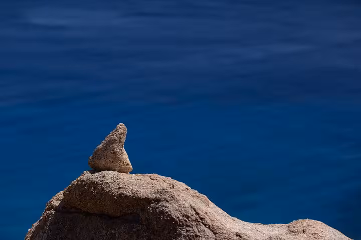 Solitary rock formation on Ikaria’s rugged west coast overlooking deep blue Aegean Sea on coastal villages tour