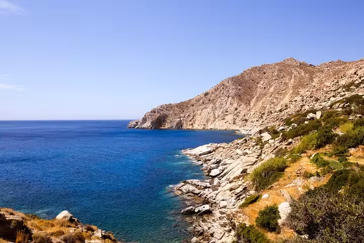 Crystal-clear blue Aegean waters meet rugged rocky coastline on Ikaria’s remote west side, ideal for scenic beach stops.