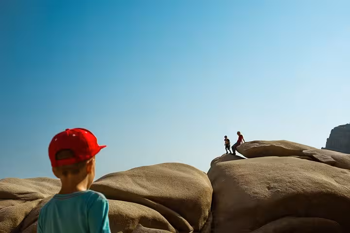 Children explore smooth coastal rock formations on Ikaria west side family-friendly tour near beaches, villages and seaside lunch