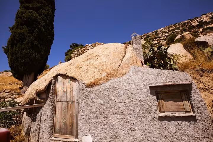 Traditional stone house built into a rock in rural Ikaria, showcasing authentic west side village architecture and nature