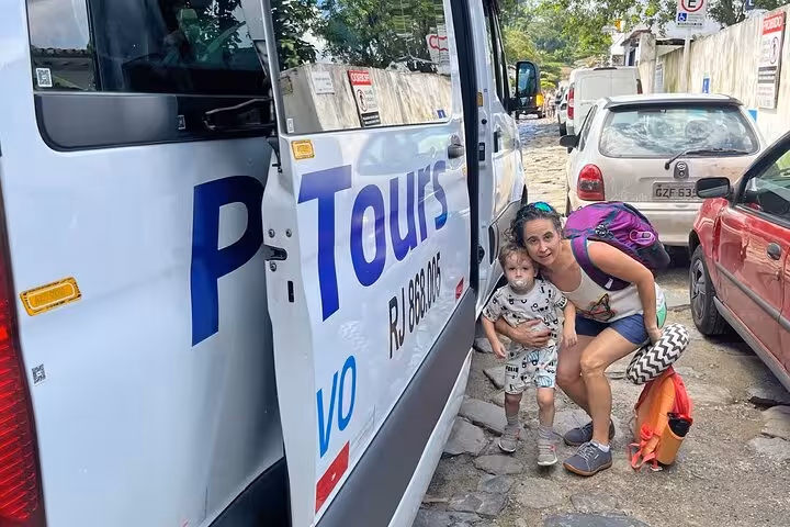Smiling travelers ready to board the shuttle van for a scenic journey from Ilha Grande to Paraty.