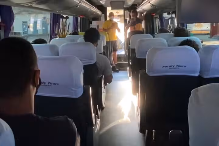 Interior of a shuttle bus with passengers seated, part of the Ilha Grande to Rio de Janeiro transfer service.