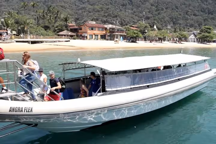 Passengers board a sleek shuttle boat at Ilha Grande, ready for a scenic transfer to Paraty under sunny skies.