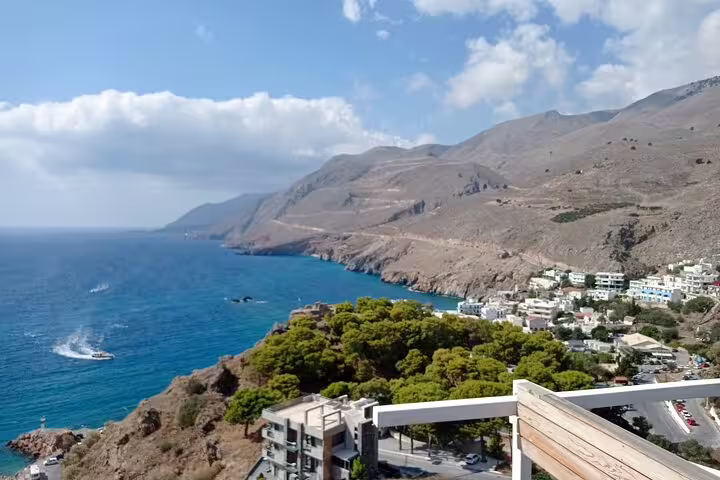 Panoramic view of Imbros Gorge coastline with rugged mountains and clear blue sea, ideal for a private adventure hike.